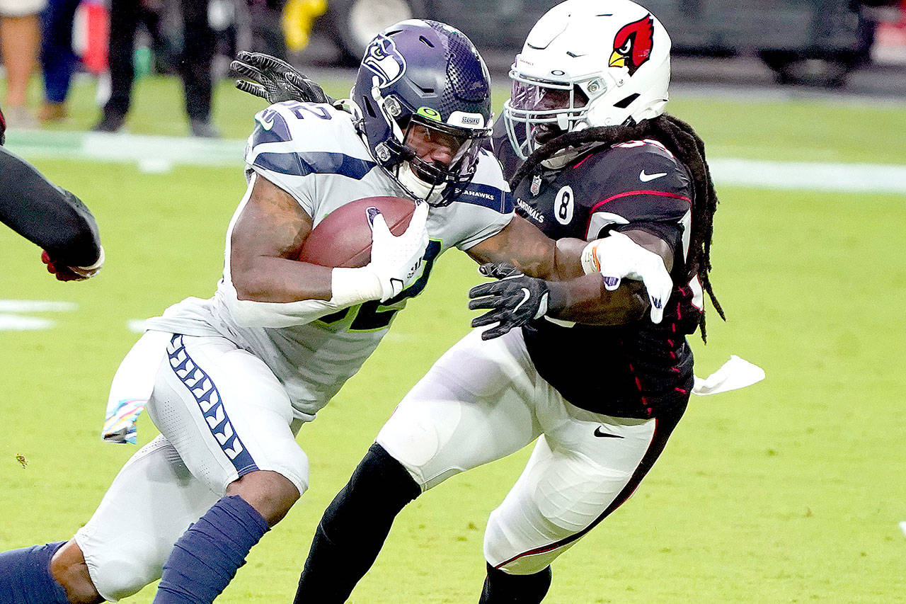 Seattle Seahawks running back Chris Carson (32) runs as Arizona Cardinals outside linebacker De’Vondre Campbell defends during the first half of an NFL football game, Sunday, Oct. 25, 2020, in Glendale, Ariz. (AP Photo/Rick Scuteri)