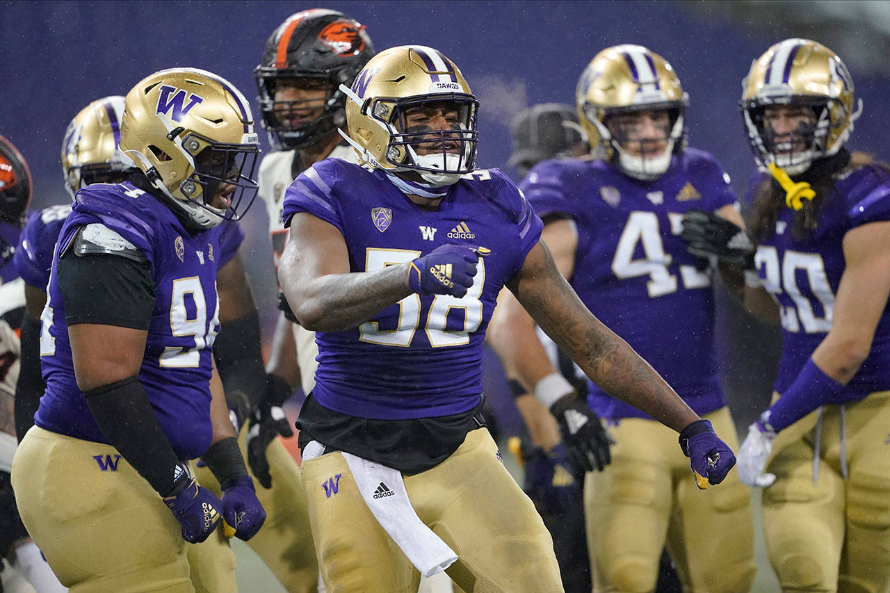 Washington’s Sam Taimani, left, and Zion Tupuola-Fetui (58) react against Oregon State during the first half of an NCAA college football game Saturday, Nov. 14, 2020, in Seattle. (Ted S. Warren/Associated Press)