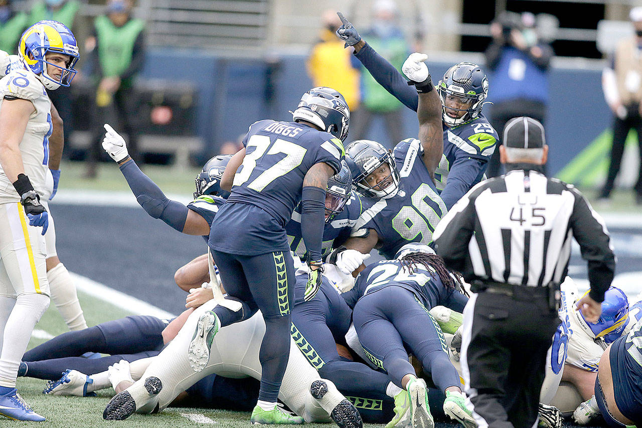 Seattle Seahawks players, including defensive tackle Jarran Reed (90) react after the Seahawks recovered a fumble during the second half of an NFL football game against the Los Angeles Rams, Sunday, Dec. 27, 2020, in Seattle. (AP Photo/Scott Eklund)