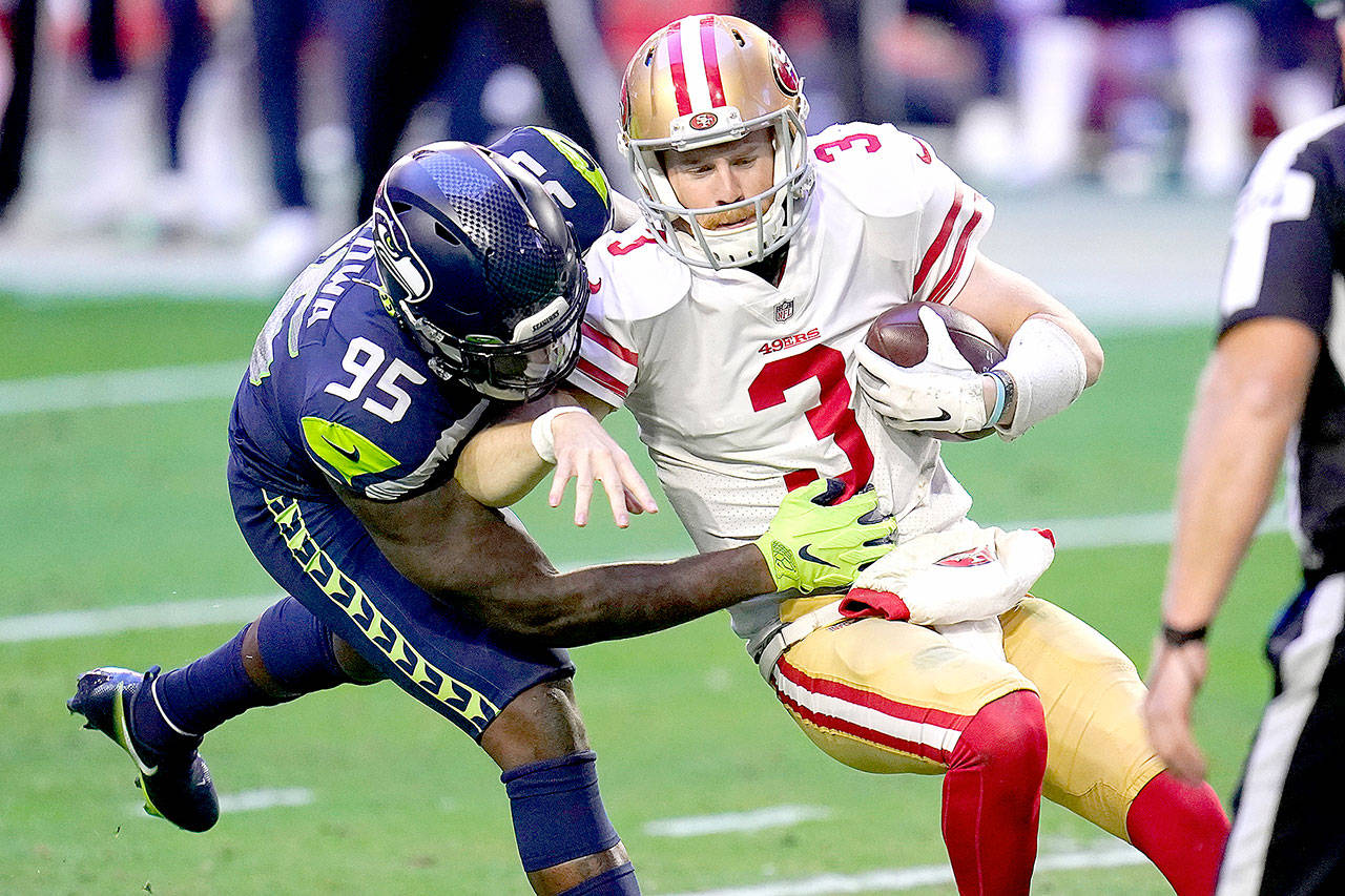 San Francisco 49ers quarterback C.J. Beathard (3) is sacked by Seattle Seahawks defensive end Benson Mayowa (95) on Sunday in Glendale, Ariz. Mayowa had a strip sack on Beathard late in the game to help seal the Seahawks’ 26-23 victory. (Ross D. Franklin/The Associated Press)