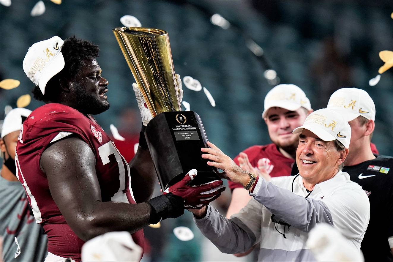 Alabama head coach Nick Saban and offensive lineman Alex Leatherwood hold the trophy after their win against Ohio State in the NCAA College Football Playoff national championship game, Tuesday in Miami Gardens, Fla. Alabama won 52-24. (Chris O’Meara/The Associated Press)