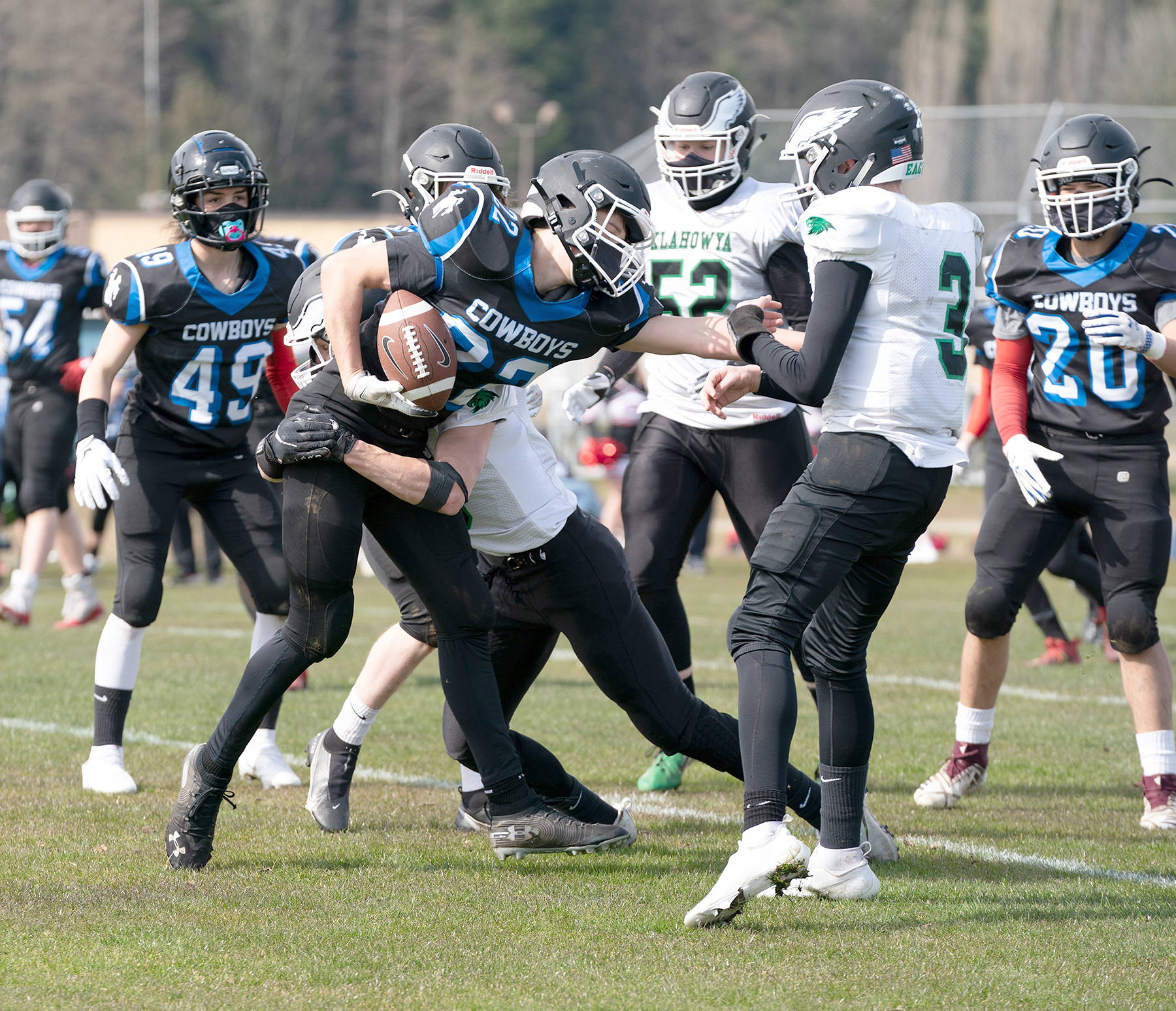 East Jefferson’s Bjorn Danaan-Devas hangs on to the ball while being tackled by a player from the Klahowya Eagles during a Saturday afternoon home game in Chimacum. Klahowya won 41-6. (Steve Mullensky/for Peninsula Daily News)
