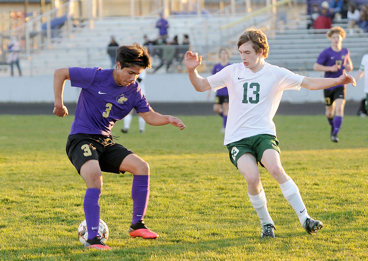 Sequim’s Cristian Gonzalez, left, looks to make a move past Port Angeles’ Josiah Long in the Wolves’ 2-0 home-opener win over the Roughriders on March 25. Michael Dashiell/Olympic Peninsula News Group
