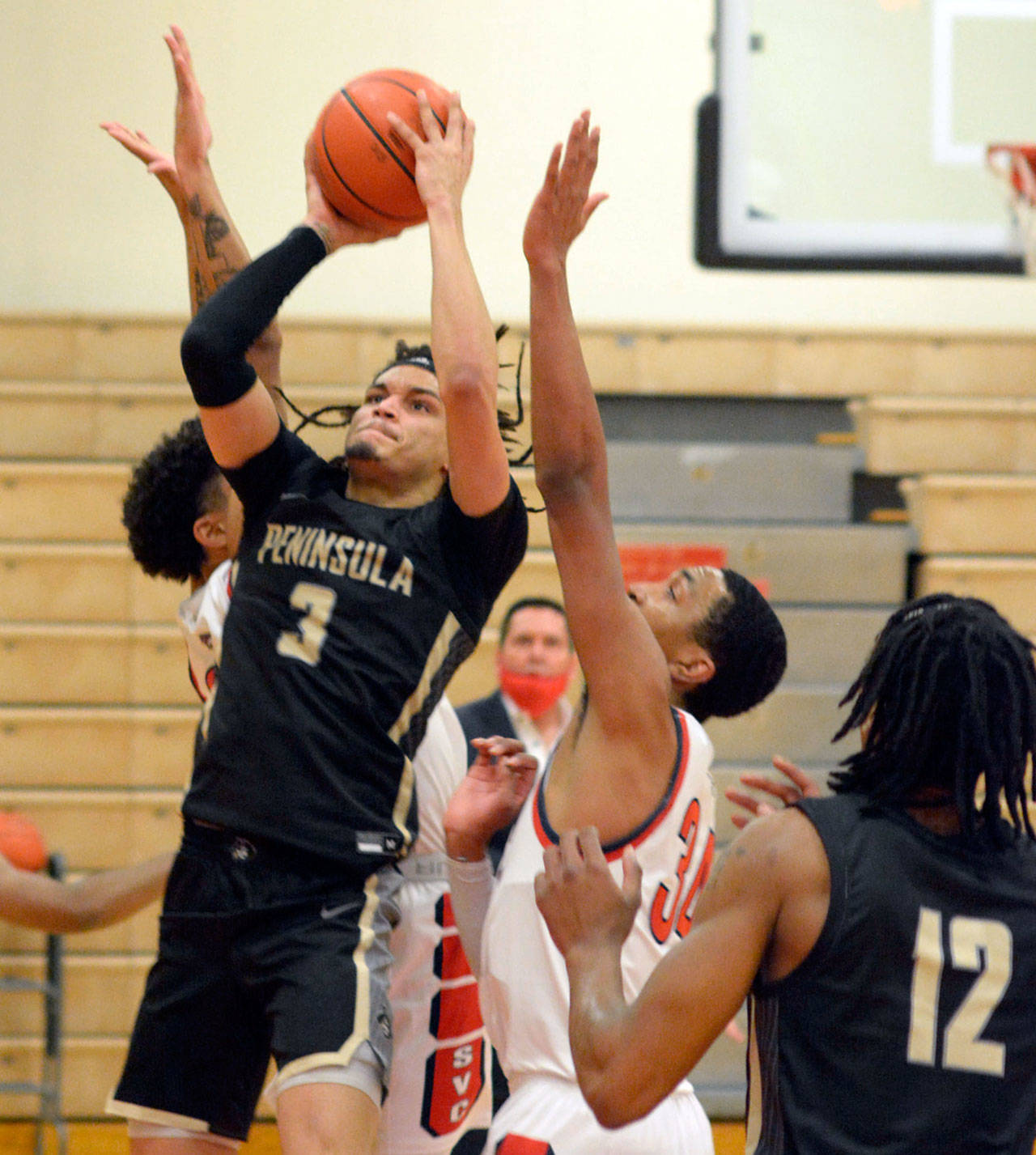 Peninsula’s Jaylin Reed looks to get off a shot while heavily defended by Skagit Valley during the Pirates’ 71-68 OT loss to the Cardinals. (Rick Ross/Peninsula College)