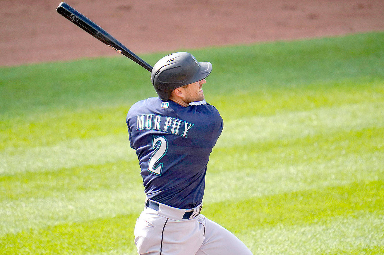 Seattle Mariners’ Tom Murphy follows through on a swing while hitting a solo home run off Baltimore Orioles starting pitcher John Means during the second inning of the first game of a baseball doubleheader, Tuesday, April 13, 2021, in Baltimore. (AP Photo/Julio Cortez)