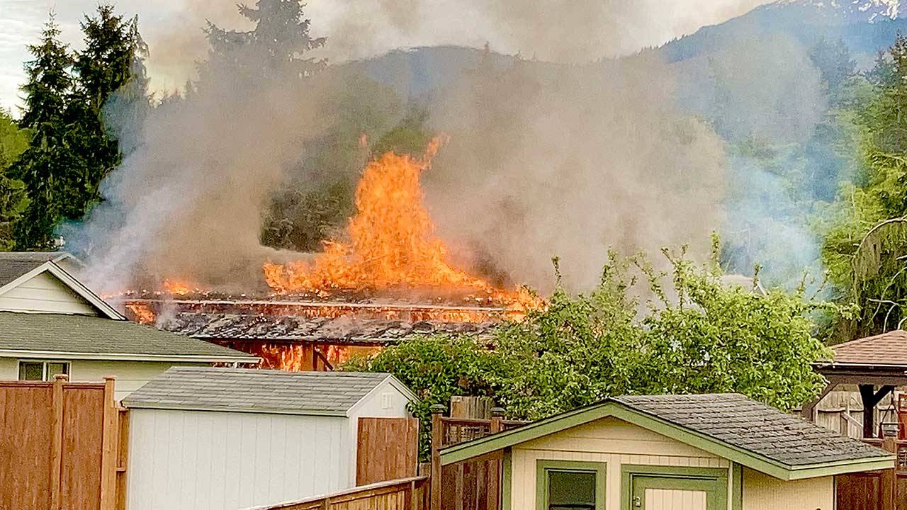 Flames shoot from the roof of a house on East Hawthorne Place on Sunday. Port Angeles Fire Department crews responded and knocked down the majority of the blaze within 10 minutes of arrival.