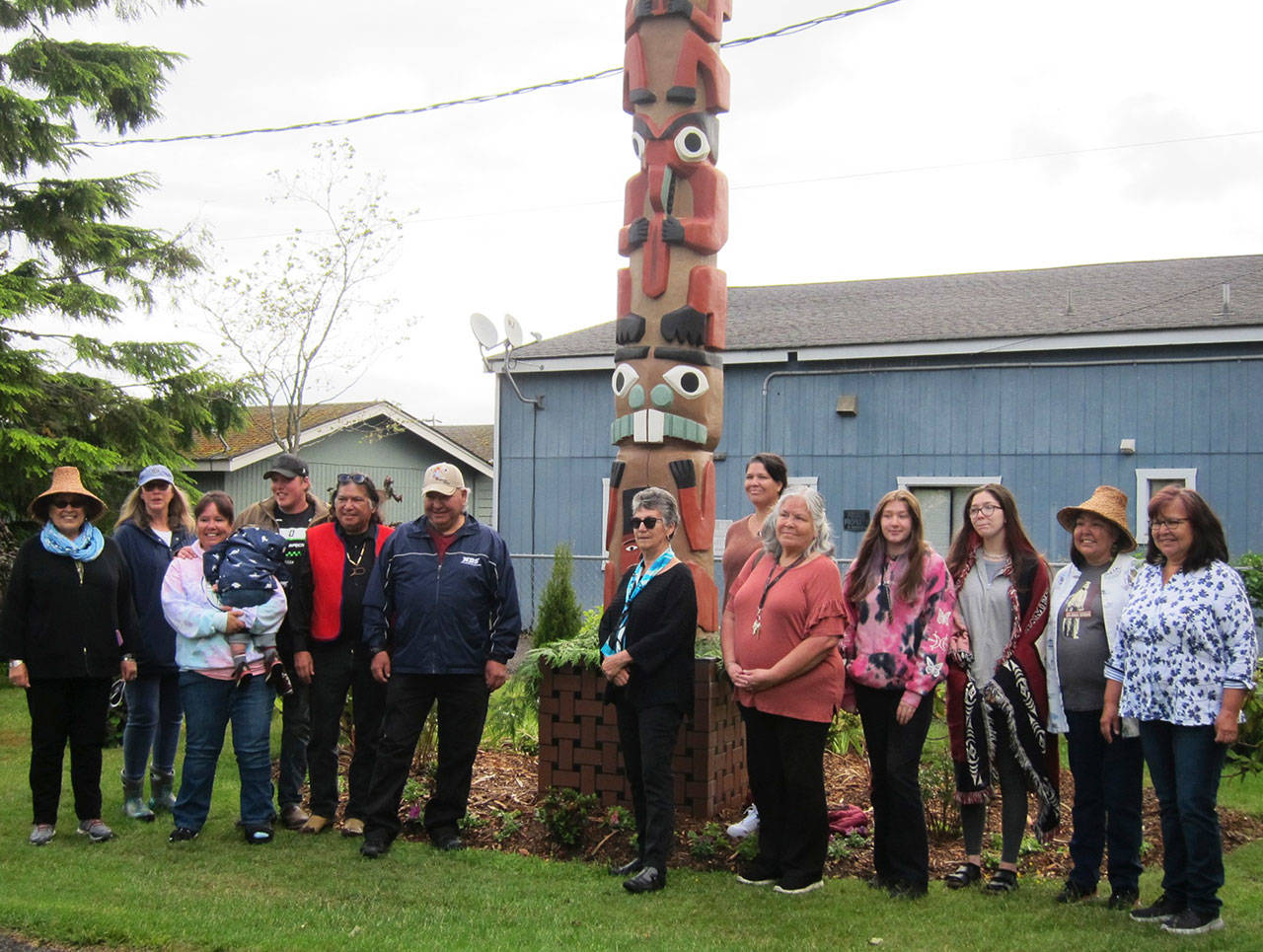 The family of Jamestown S’Klallam Tribal elder Harris “Brick” Johnson celebrate a rededication of his totem at Pioneer Memorial Park on June 5. Family members include, from left, Sandy Johnson, Rosalynn McKenna, Shawna Priest holding Jameson Carver, Josh Carver, Terry Johnson, Steve Johnson, Rosie Zwanziger, Jessica Johnson, Vickie Carroll, Sonni and Jolie Creech, Susan Johnson and Verna Johnson. Photo courtesy of Betty Oppenheimer/Jamestown S’Klallam Tribe