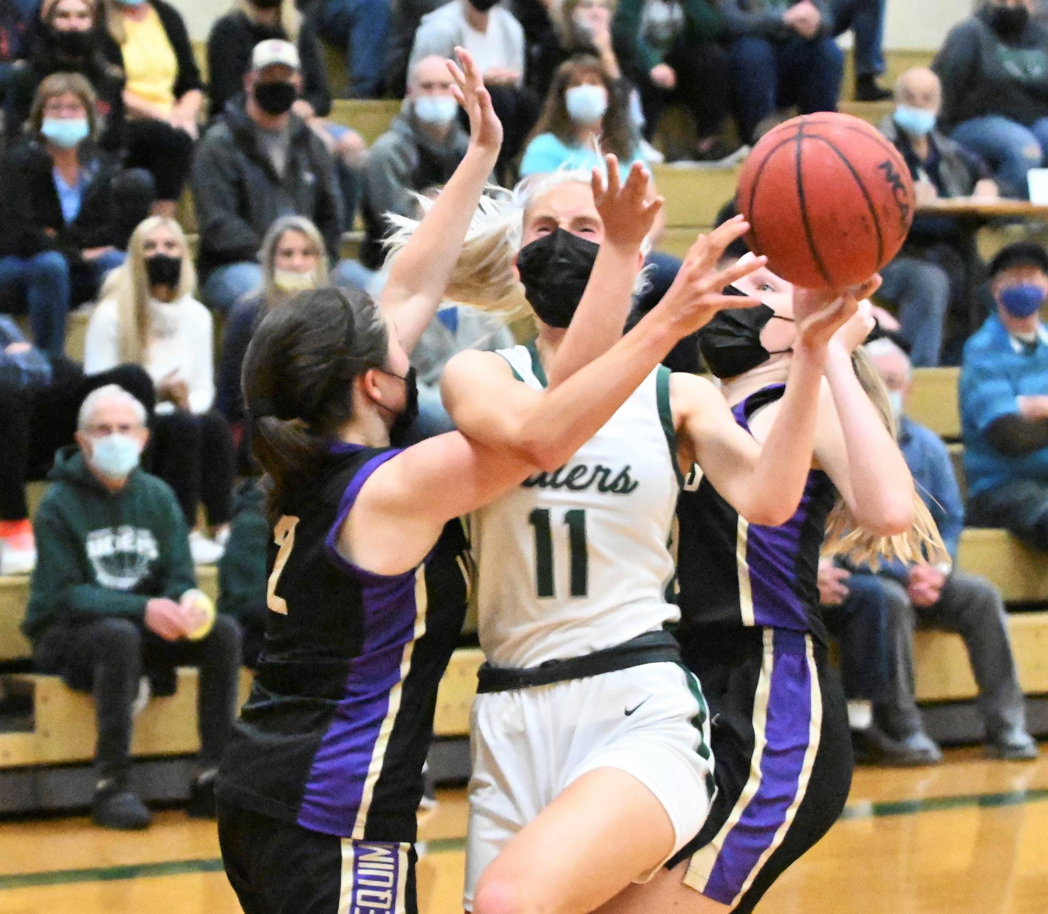 Michael Dashiell/Olympic Peninsula News Group Port Angeles’ Millie Long is defended by Sequim’s Hannah Bates (2) and Jolene Vaara. Port Angeles won 68-52 to win the Olympic League Tournament and finish a perfect season at 15-0.