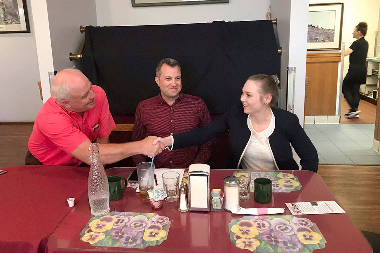 Port Angeles City Council candidates John Madden and Samantha Rodahl shake hands Tuesday following an election forum while incumbent Mike French looks on. (Paul Gottlieb/Peninsula Daily News)