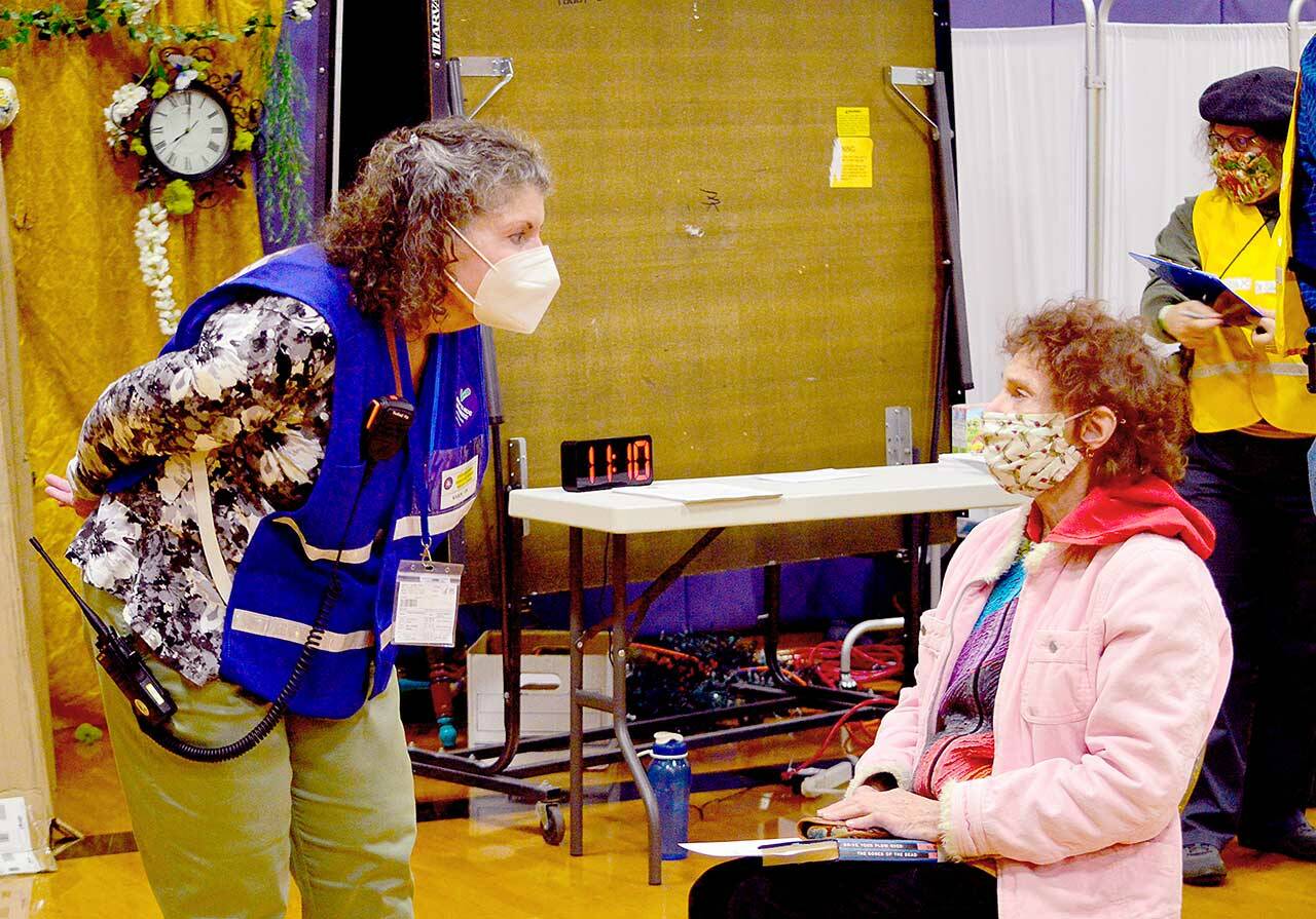 Volunteer nurse Karen Easterly-Behrens of Port Ludlow, left, talks with Eliana Rose of Port Townsend at Saturday’s Pfizer booster clinic at Quilcene School. The county Department of Emergency Management worked with dozens of volunteers to organize the clinic. (Diane Urbani de la Paz/Peninsula Daily News)