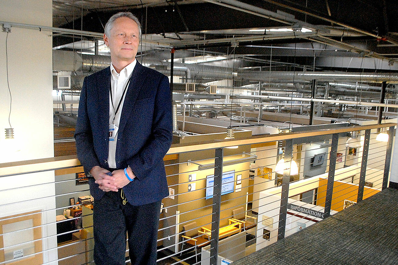 Michael Maxwell, chief executive officer of the North Olympic Healthcare Network, stands on a balcony overlooking the organization's main clinic in downtown Port Angeles on Wednesday. (Keith Thorpe/Peninsula Daily News)