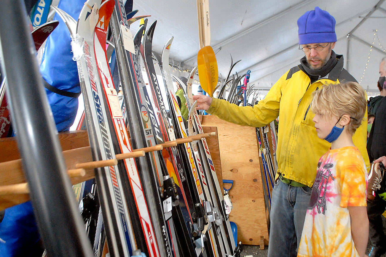 Ned Hammar of Port Angeles and his son, Felix Lubinski Hammar, 9, examine a rack of snow skies during Saturday’s Winterfest ski swap in the Black Ball Ferry parking lot on the Port Angeles waterfront. The event, a fundraiser for the Hurricane Ridge Winter Sports Club, featured a variety of skis, snowboards and related sports gear. No total from the event was available on Sunday. (Keith Thorpe/Peninsula Daily News)
