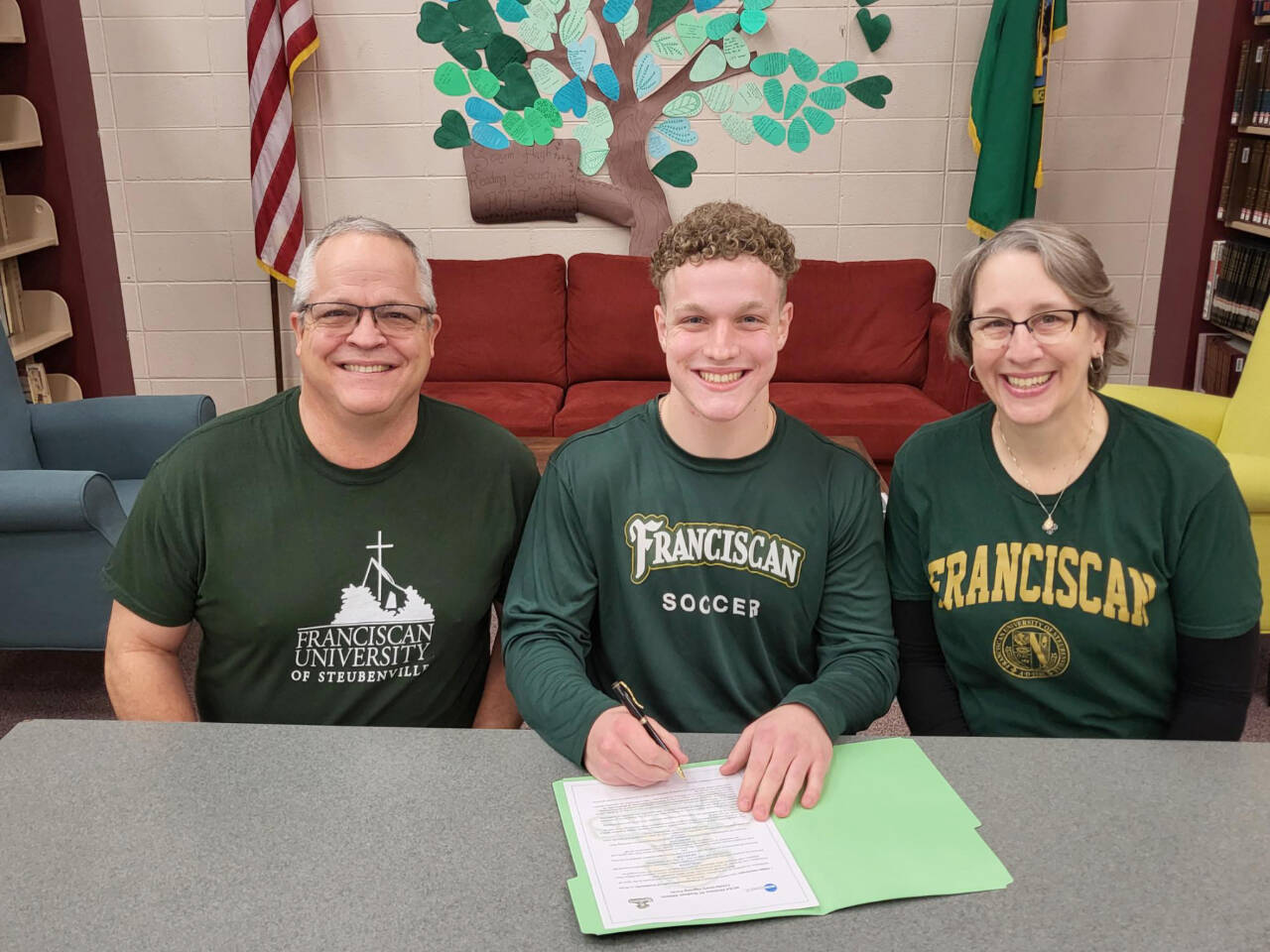Aiden Henninger of Sequim, with his father, Ray, left and mother Ann Marie Henninger, signs to play soccer at Franciscan University in Steubenville, Ohio.