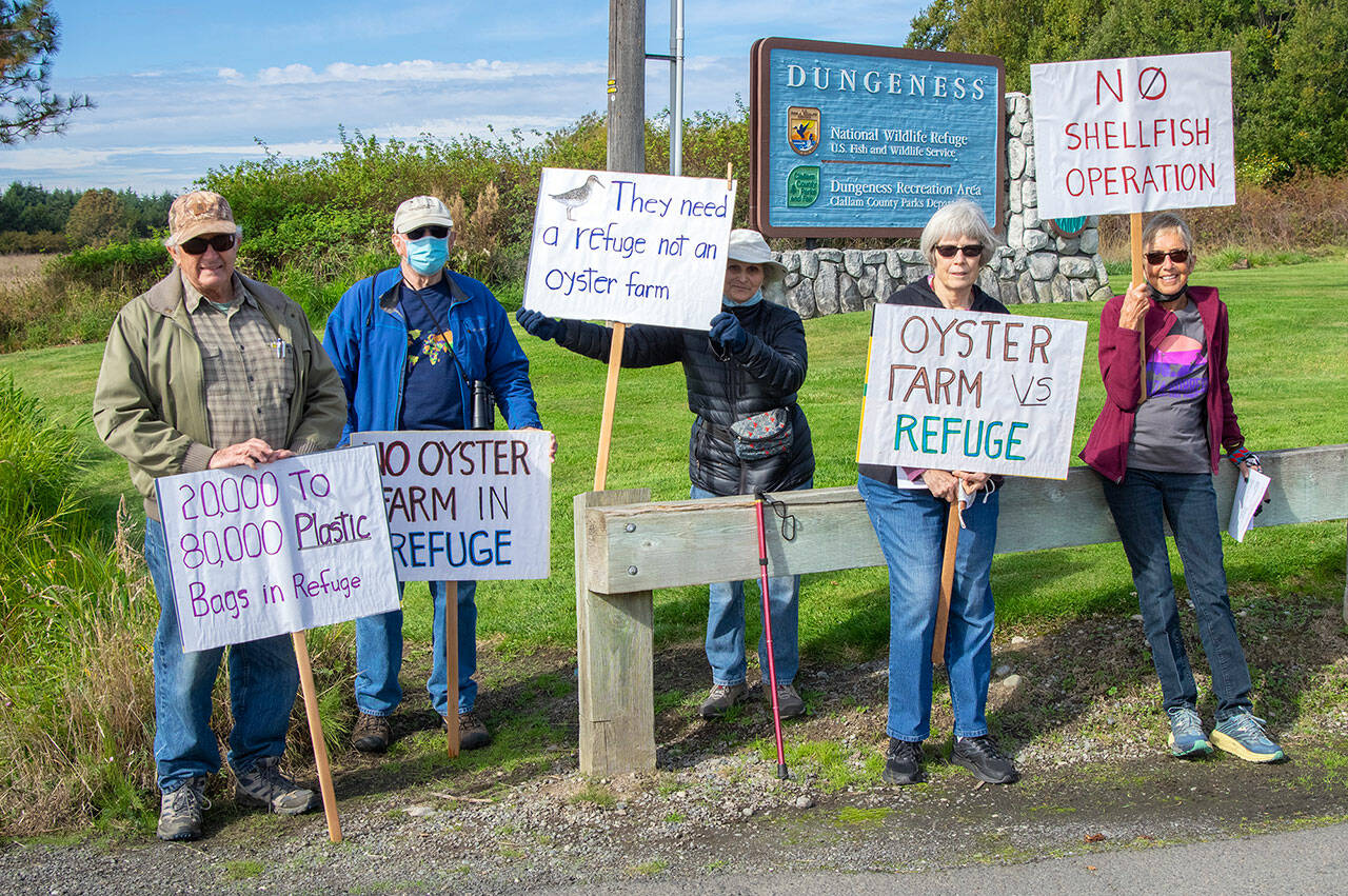 From left, Norm Baker, Jim Karr, Darlene Schanfald, Janet Marx and Jane Erickson gather at the entrance to the Dungeness Wildlife Refuge off Lotzgesell Road in Sequim to protest a future oyster farm planned for the refuge and to hand out fliers of information to people entering the refuge and Dungeness Recreation Area. (Sequim Gazette photo by Emily Matthiessen)