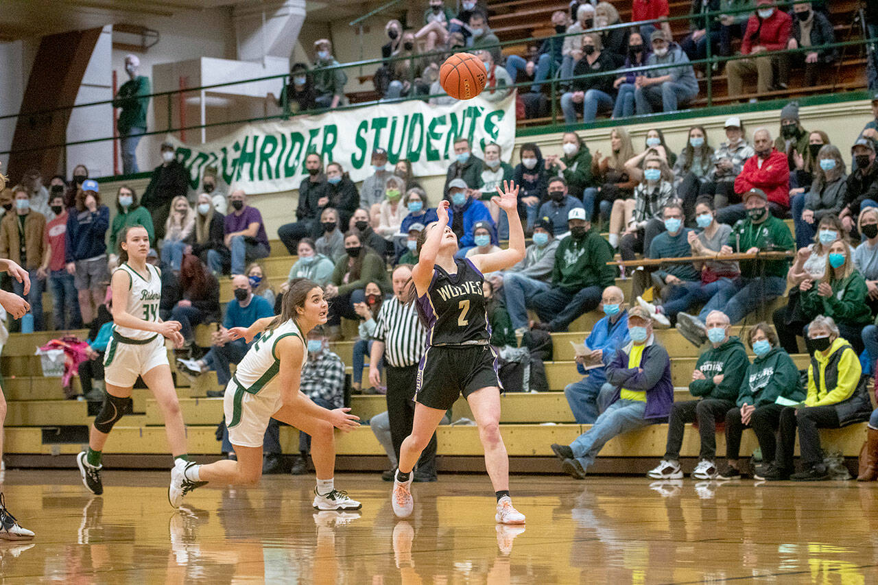 Jesse Major/For Peninsula Daily News Port Angeles’ Eve Burke, left, and Sequim’s Hannah Bates eye a loose ball during the Roughriders’ 60-36 Senior Night win over the Wolves.