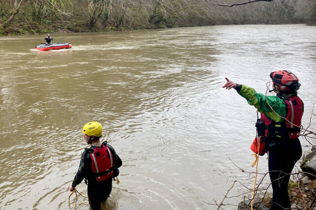 A swift-water rescue team from Clallam County Fire District 1 works to bring a man to shore after an inflatable raft overturned Sunday in the Calawah River. (Clallam County Fire District 1)