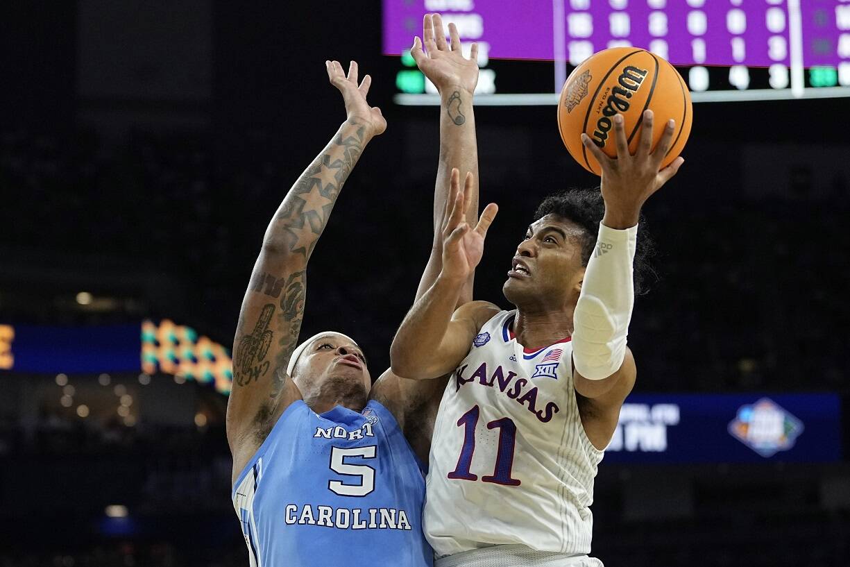 Kansas guard Remy Martin shoots around North Carolina forward Armando Bacot during the second half of a college basketball game in the finals of the Men's Final Four NCAA tournament, Monday  in New Orleans. (AP Photo/David J. Phillip)