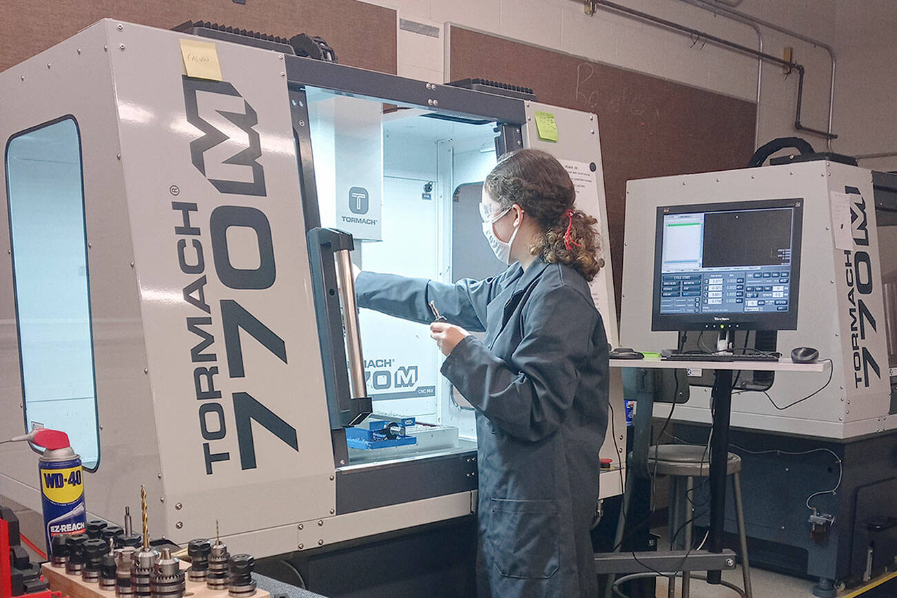 Port Townsend High School senior Haley Jones operates a computer-numeric control (CNC) milling machine, one of the pieces of equipment she learned to use in Tim Behrenfeld's computer-integrated manufacturing course.  photo by Tim Behrenfeld