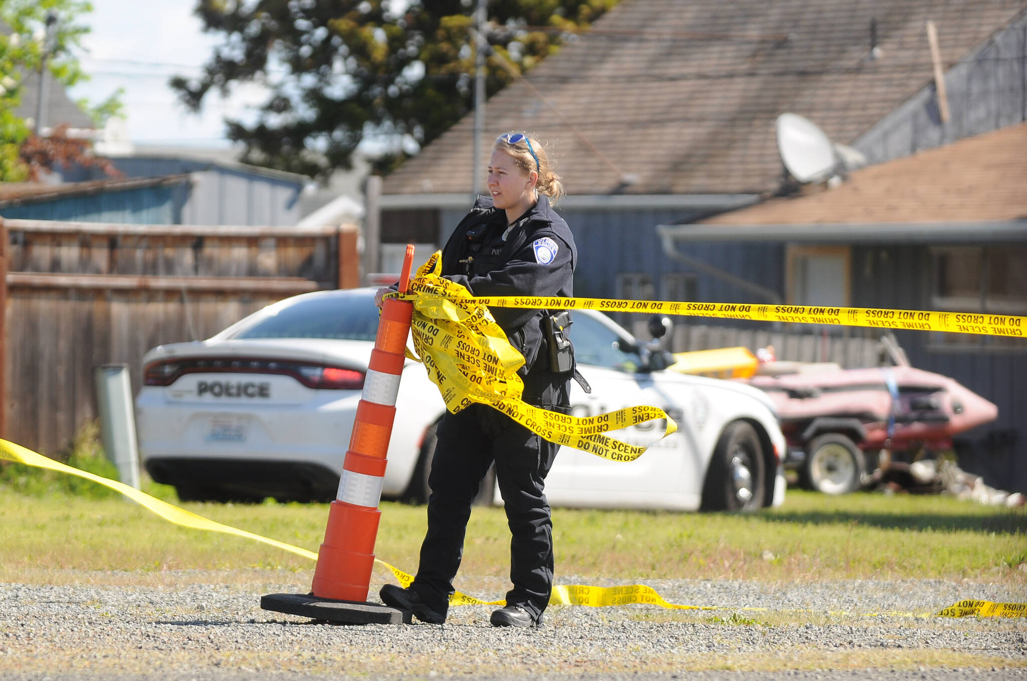 A Port Angeles police officer cordons off an empty lot at West Washington Street and Third Avenue Thursday morning as law enforcement officials investigate an incident in the area. (Michael Dashiell/Olympic Peninsula News Group)
