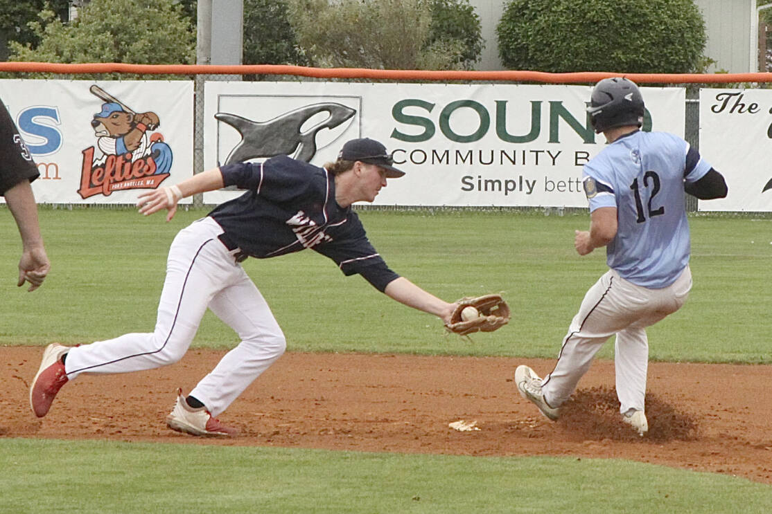 Wilder Sr.'s Wyatt Hall, with ball, tries to tag out a Bellingham Post No. 7 baserunner at second base at Civic Field on Monday. (Dave Logan/for Peninsula Daily News)