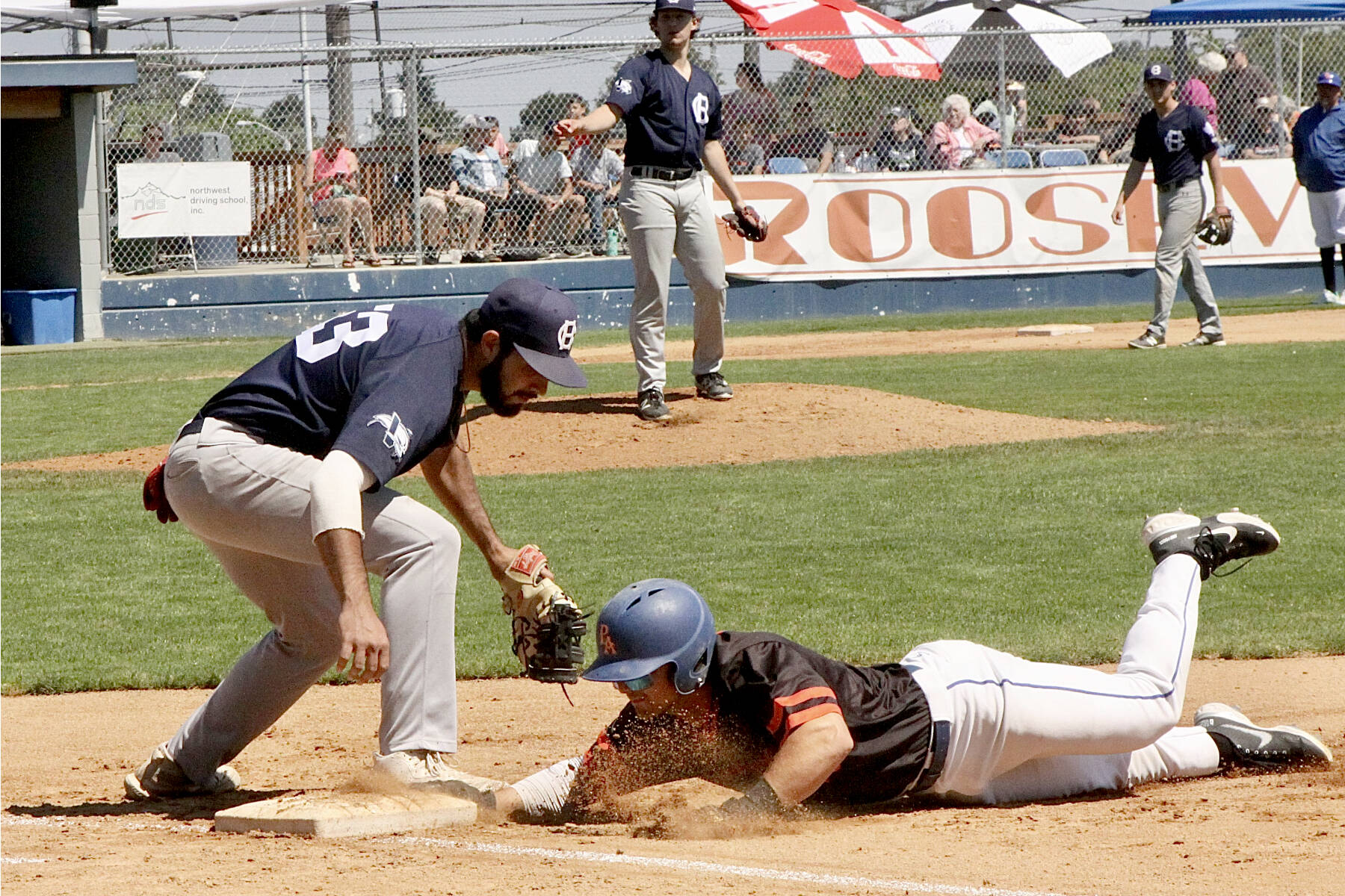 Adam Paganelli of the Port Angeles Lefties gets back to first base safely just before the tag of Victoria HarbourCats first baseman Roberto Gonzalez on a pickoff play. (Dave Logan/for Peninsula Daily News)