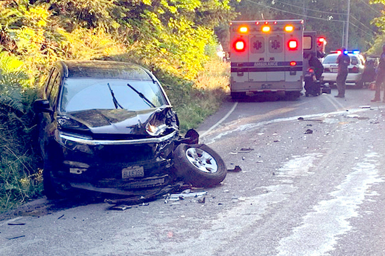 The stolen black 2022 Dodge sits mangled on the roadside. The pickup had collided head-on with a 2016 Honda Pilot after a short pursuit. (Clallam County Sheriff’s Office)