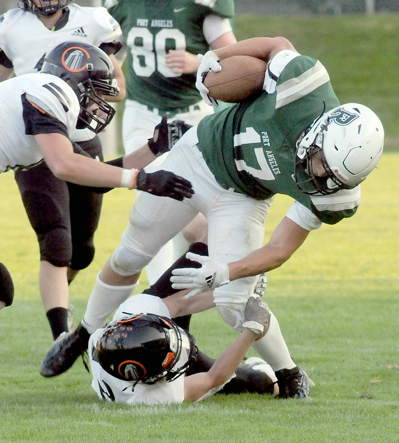 Port Angeles’ Jason Hawes is brought down by Blain’s Riley Ihde and Mallory Messenger, left, in second quarter play on Friday evening in Port Angeles. (Keith Thorpe/Peninsula Daily News)
