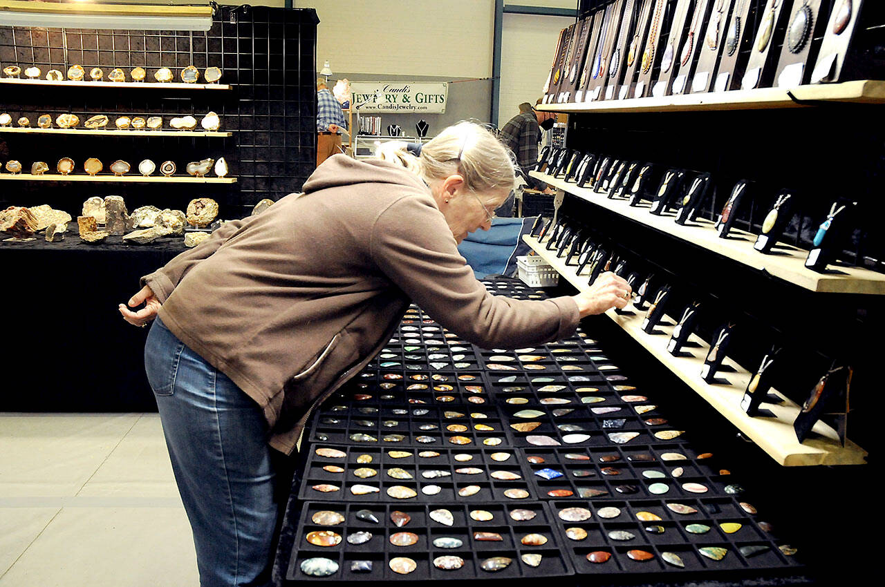 Laurie Nichols of Port Angeles examines a display of gems and pendants at the Rock, Gem & Jewelry Show at Vern Burton Community Center in Port Angeles. The show, hosted by the Clallam County Gem & Mineral Association over the weekend, featured a wide variety of rocks, minerals, crystals and fossils from around the world for sale and for show. (Keith Thorpe/Peninsula Daily News)