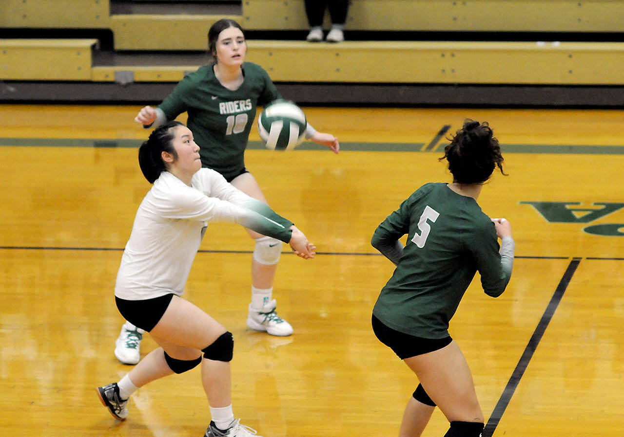 KEITH THORPE/PENINSULA DAILY NEWS Port Angeles libero Cindy Liang, center, passes the ball as fellow back row teammates Jasmine Messinger, upper left, and Karma Williams look on during Thursday’s match against Kingston at Port Angeles High School.