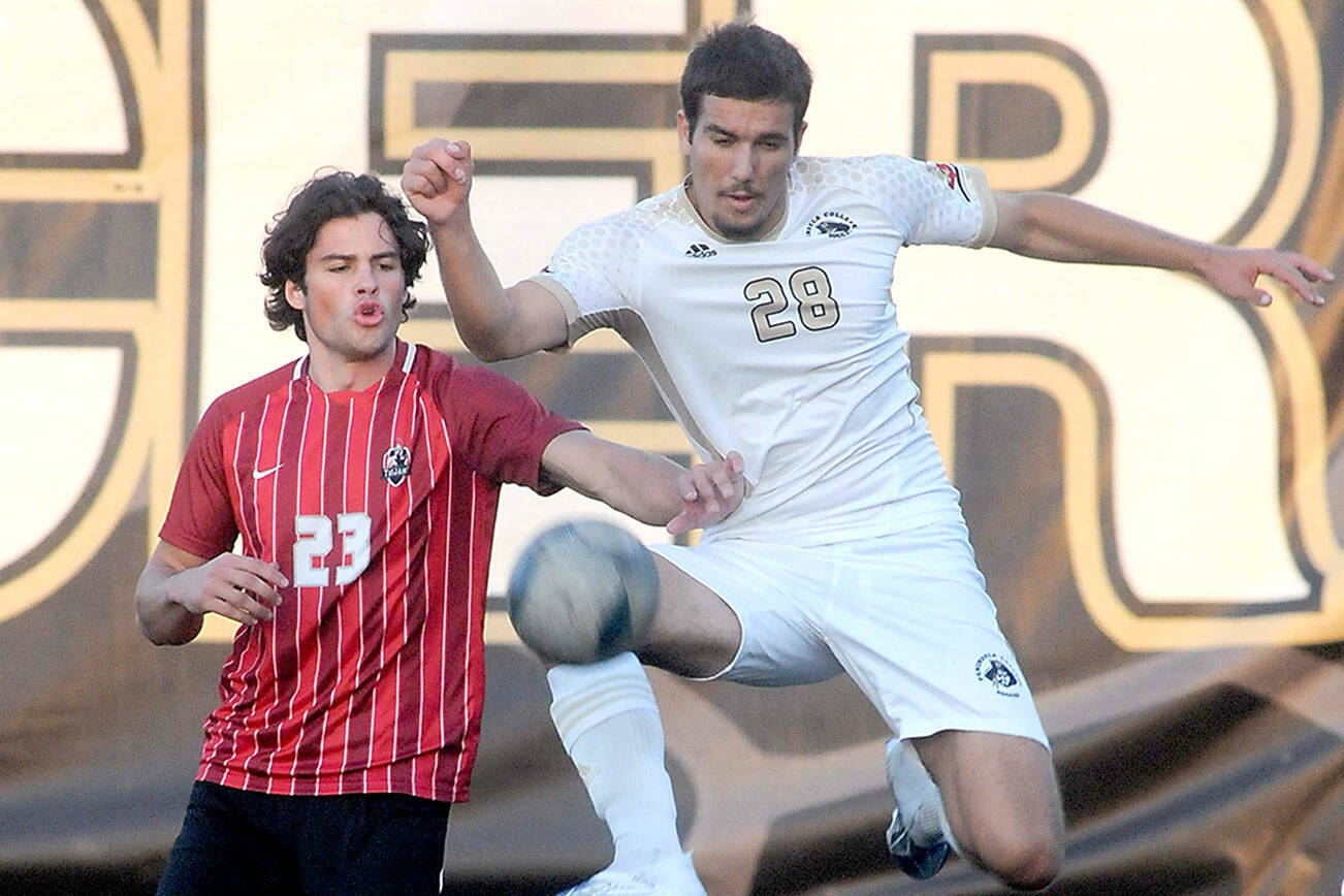KEITH THORPE/PENINSULA DAILY NEWS
Peninsula's Kai Biegler, right, leaps high to keep the ball away from Everett's River Stewart during Saturday's match at Peninsula College in Port Angeles.