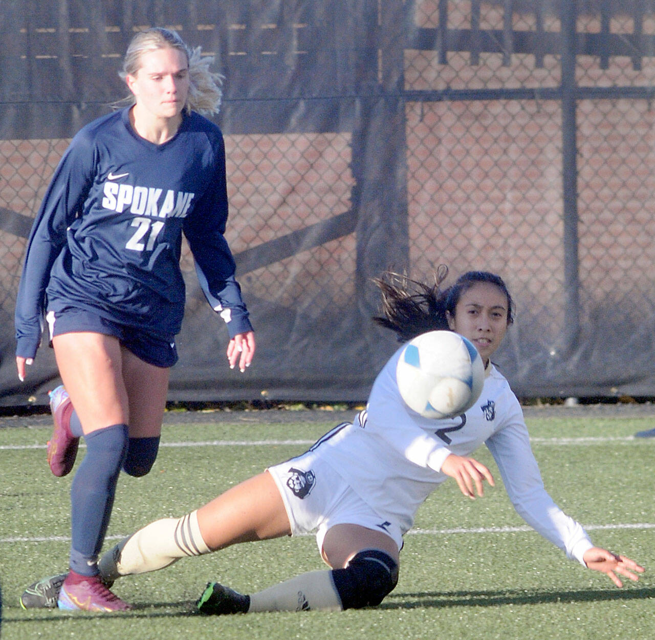 Peninsula’s Briana-Jean Tanaka, right, makes a sliding tackle on Spokane’s Peyton Bastine on Saturday in Port Angeles. (Keith Thorpe/Peninsula Daily News)