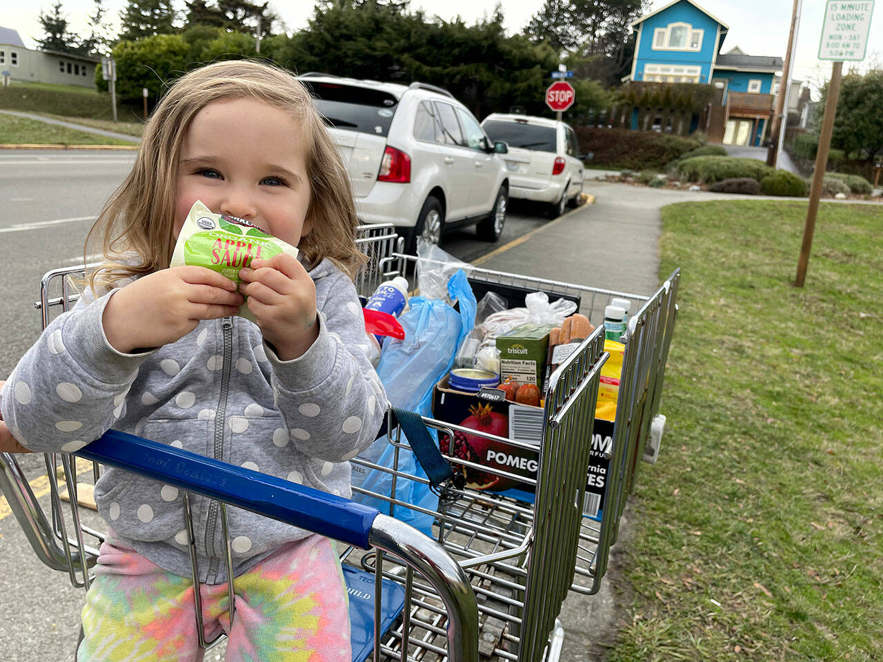 Lola Siegel, 3, enjoys some apple sauce from the Port Townsend Food Bank, which has seen an uptick in clients over the past year. It was the first trip to the food bank for Lola and her father, Jonas Siegel, who said that he appreciated the organic and vegetarian options at the food bank. (Paula Hunt/Peninsula Daily News)