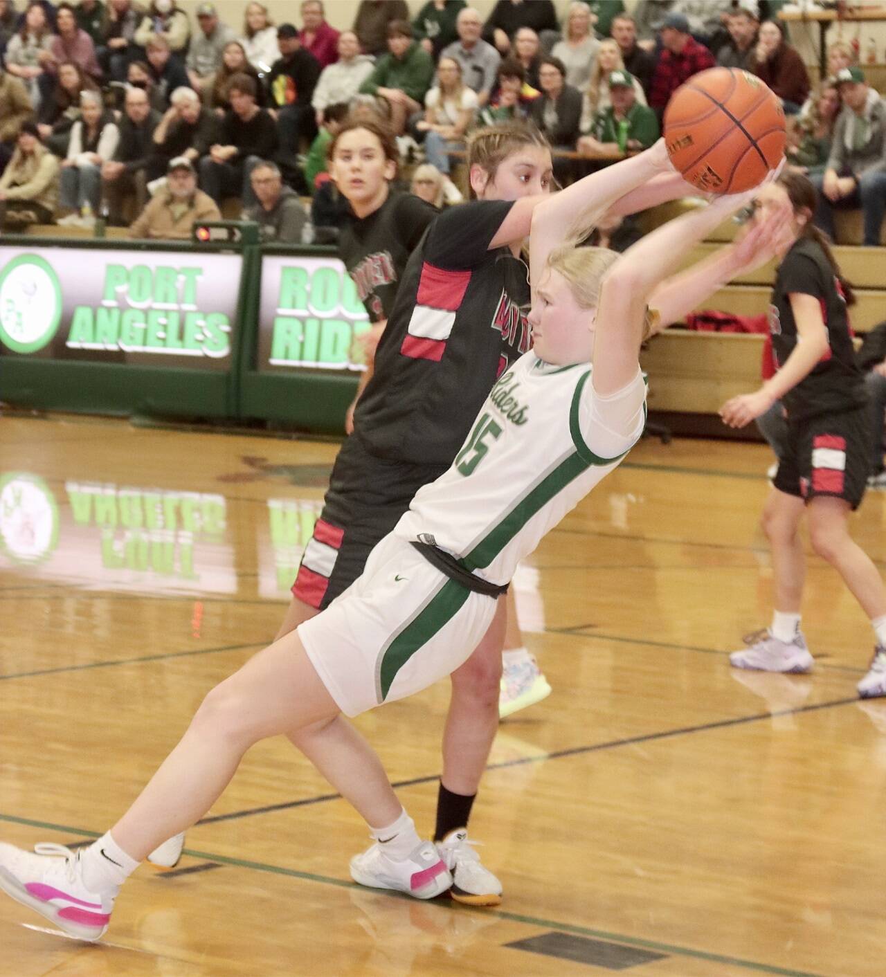 Neah Bay’s Ryana Moss and Port Angeles’ Paige Mason battle over a rebound Saturday at Port Angeles High School. The No. 1-ranked Red Devils won 60-41. (Dave Logan/for Peninsula Daily News)