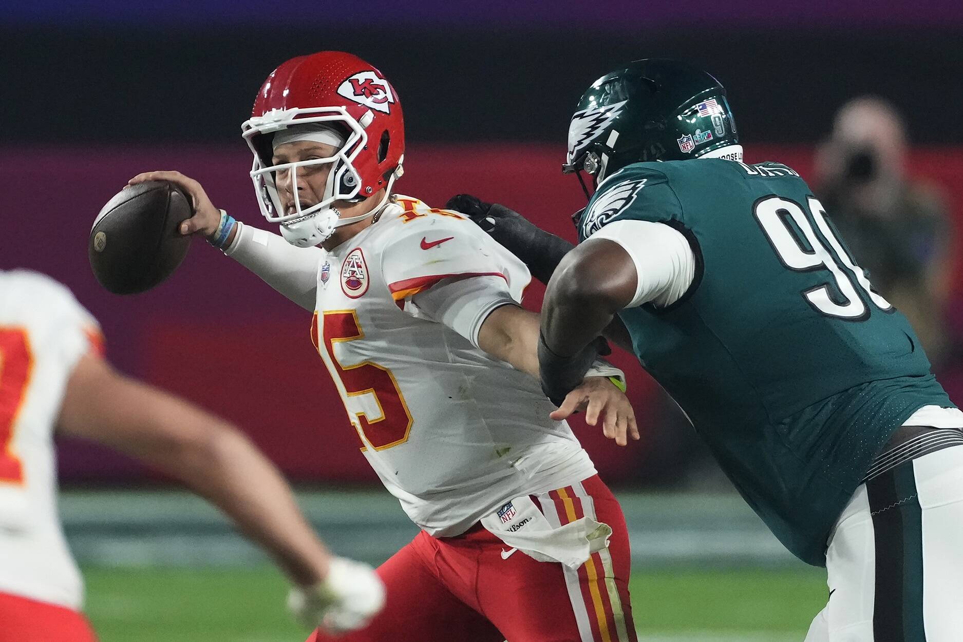 Kansas City Chiefs quarterback Patrick Mahomes (15) passes under pressure from Philadelphia Eagles defensive tackle Jordan Davis (90) during the second half of the NFL Super Bowl 57 football game, Sunday, Feb. 12, 2023, in Glendale, Ariz. (AP Photo/Ross D. Franklin)