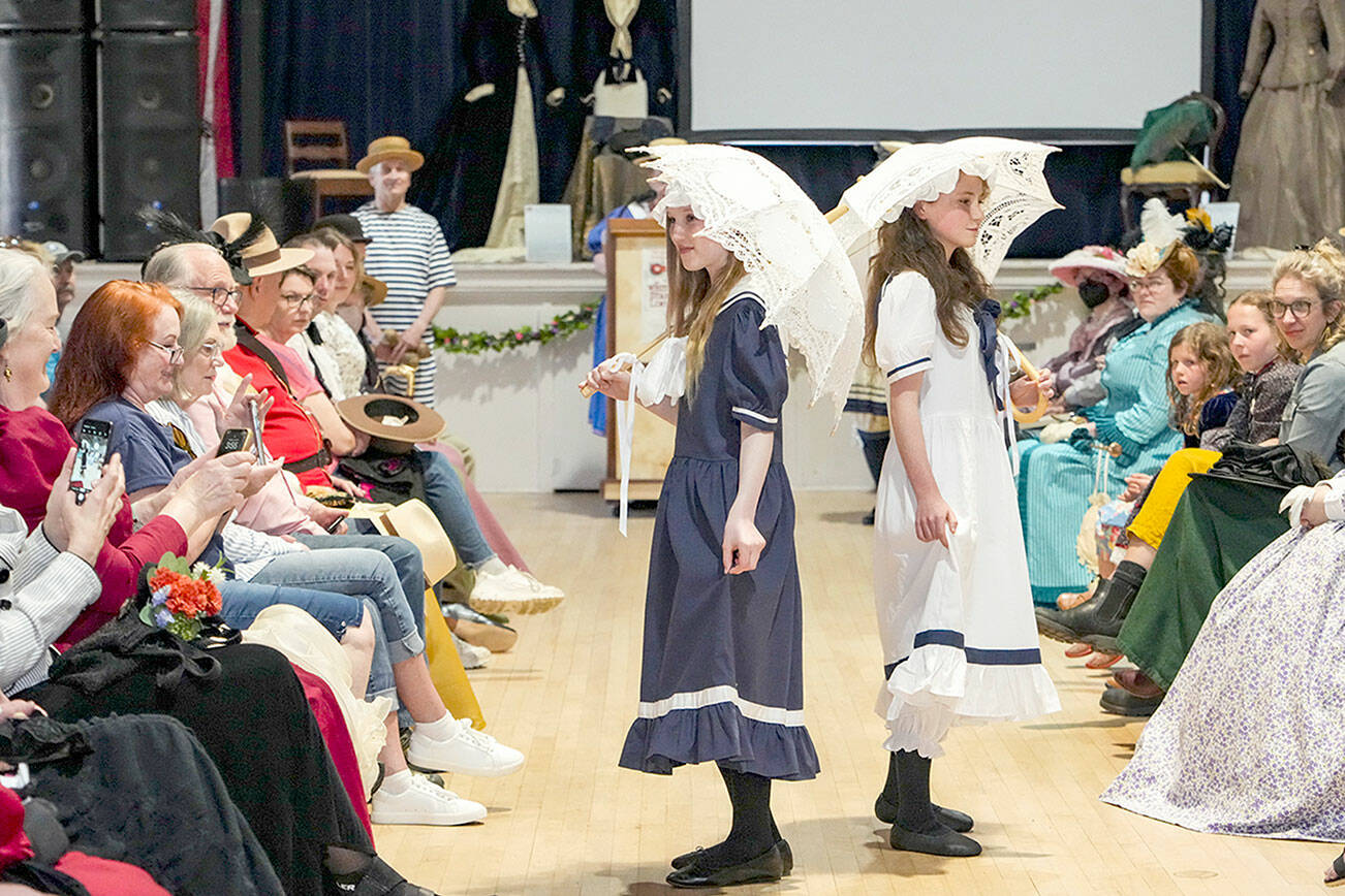 Molly Yanoff Odell, 12, and Darby Berg, 12, both from Port Townsend, model 1890 swimwear costumes during a Victorian Era fashion show at the Legion Hall on Saturday. The girls took part in the Port Townsend Victorian Heritage Festival, which was at various venues over the weekend. (Steve Mullensky/for Peninsula Daily News)
