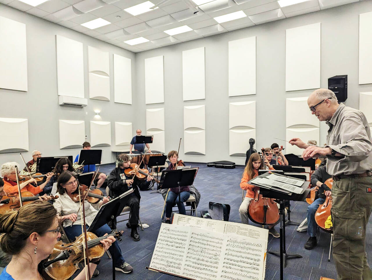 Conductor/music director Phil Morgan-Ellis leads a Sequim Community Orchestra rehearsal on April 25 at the Sequim City Band’ expanded rehearsal hall at the James Center for Performing Arts. The orchestra closes its 11th season with a free concert and bake sale at 7 p.m. on Saturday, May 13, at Trinity United Methodist Church. (Photo courtesy of Sequim Community Orchestra)