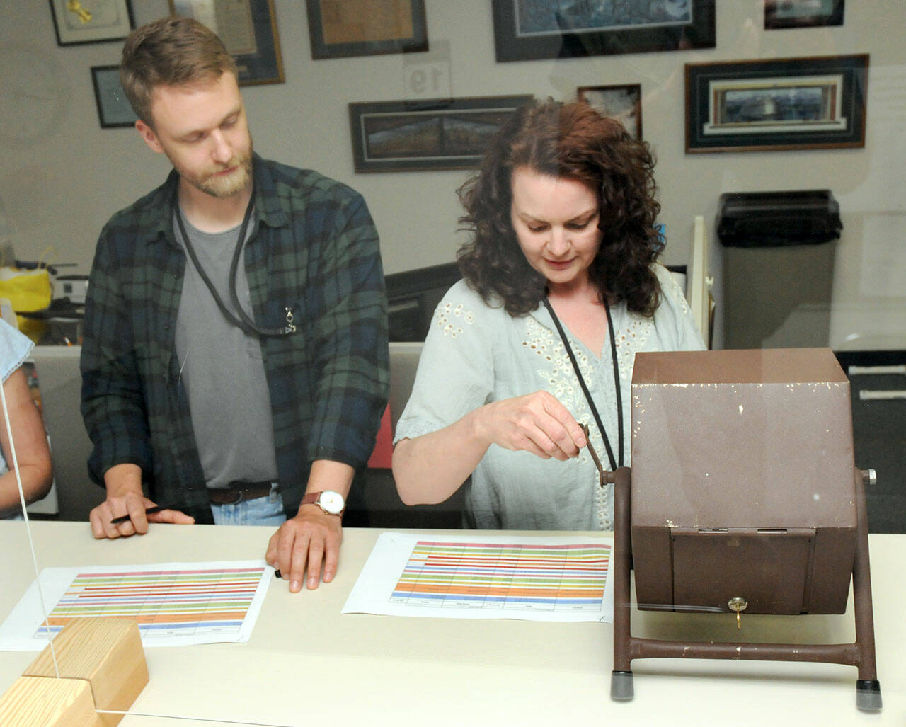 Clallam County election assistant Gretchen Weeks, right, spins a tumbler containing the names of candidates as county voter registration coordinator Joshua Hart records the results during a lot drawing for candidate positions on the ballot on Friday at the county courthouse in Port Angeles. (KEITH THORPE/PENINSULA DAILY NEWS)