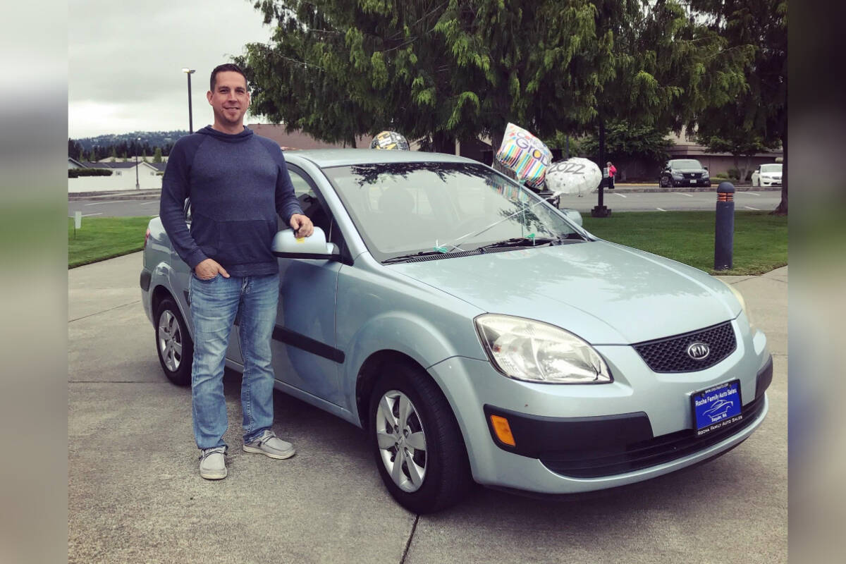 Owner Michael Rocha with a previous year's prize vehicle given away by Rocha Family Auto Sales.