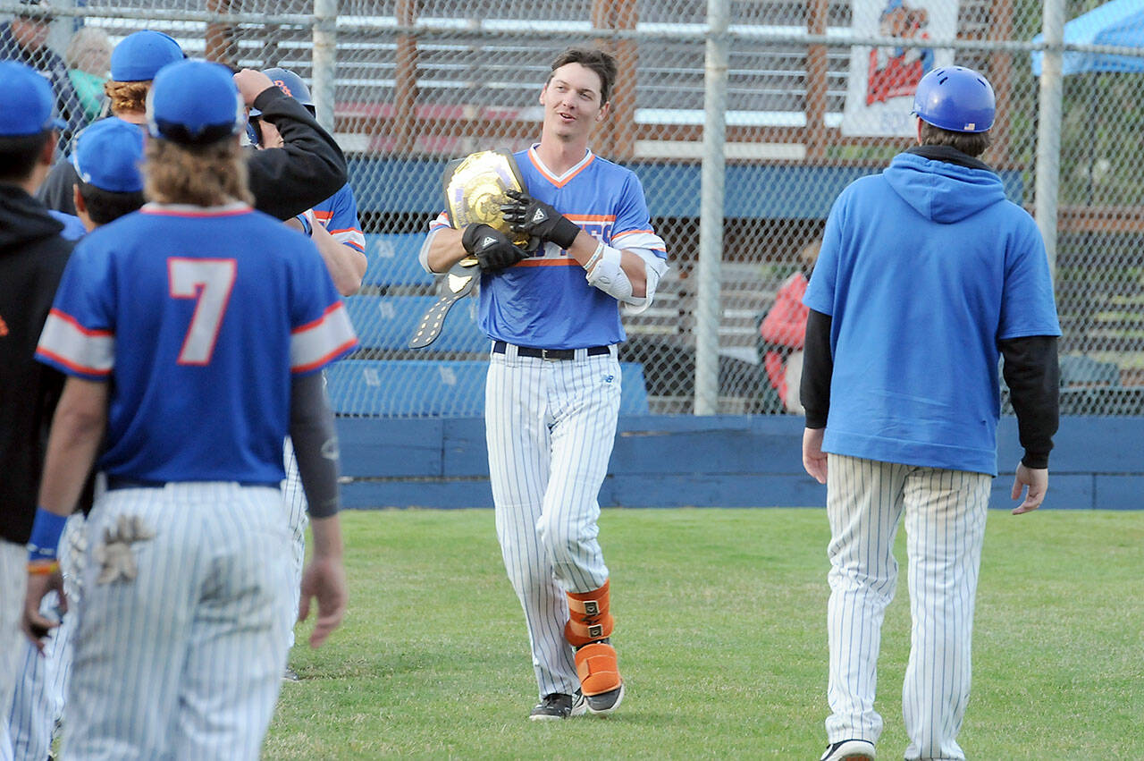 Lefties center fielder Kam Koester carries the Next Door Gastropub Bomb Belt back to the dugout that was was handed to him by a teammate after rounding the bases with a two-run homer in the third inning against the Nanaimo NightOwls on Tuesday night in Port Angeles. (Keith Thorpe/Peninsula Daily News)