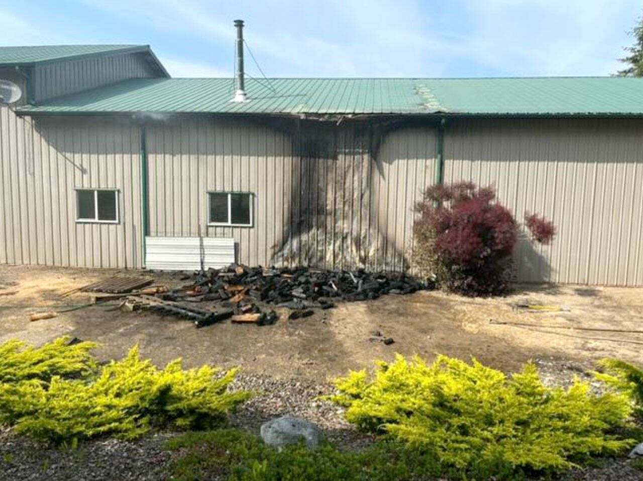 A fire destroyed a wood pile and damaged a large shed with an attached living area. (Chris Turner)