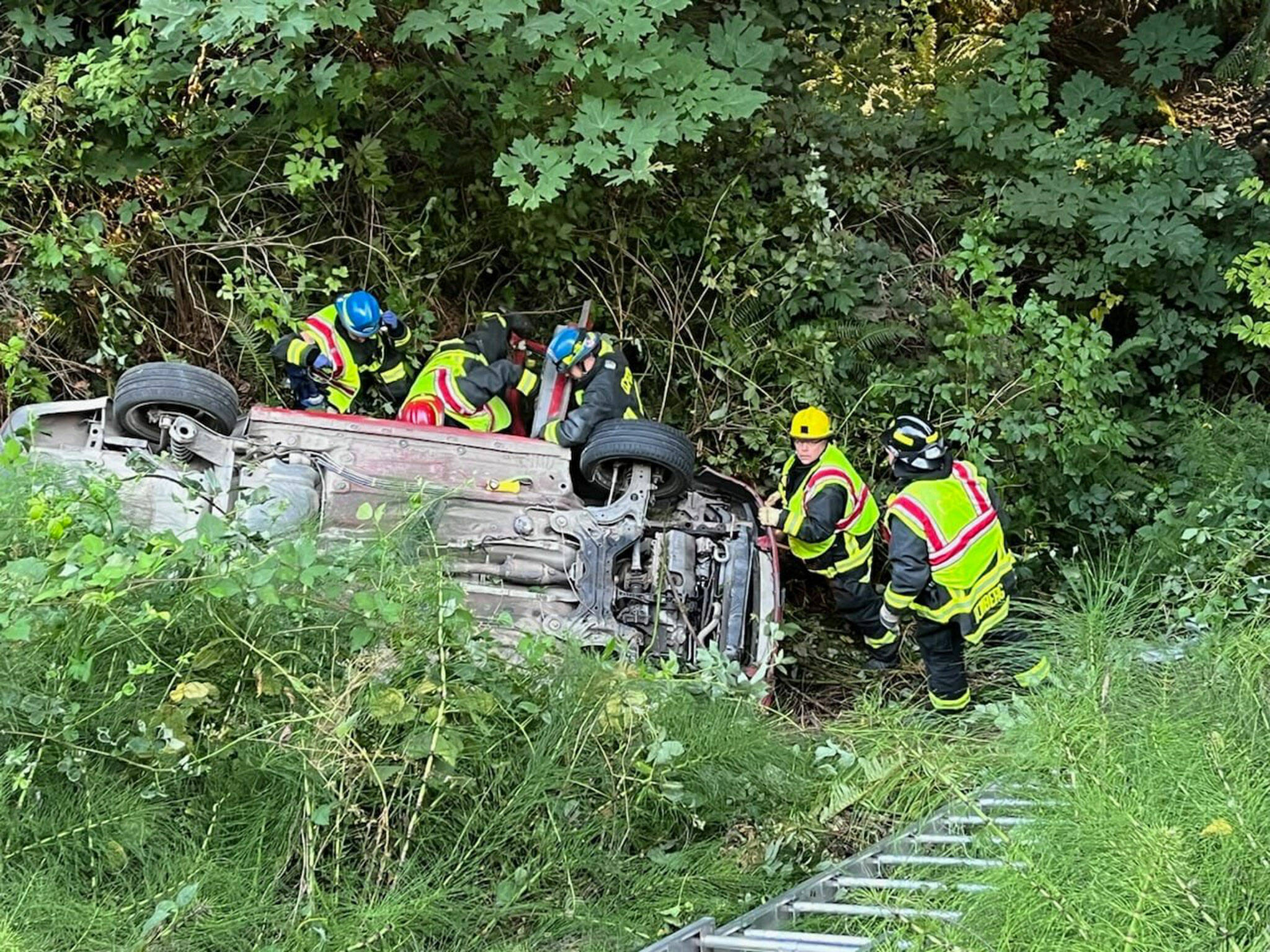 First responders prevent a vehicle from sliding farther down an embankment after it went off U.S. Highway 101 Monday evening. Its driver, a 61-year-old Sequim woman, died in the crash. (Clallam County Fire District 3)