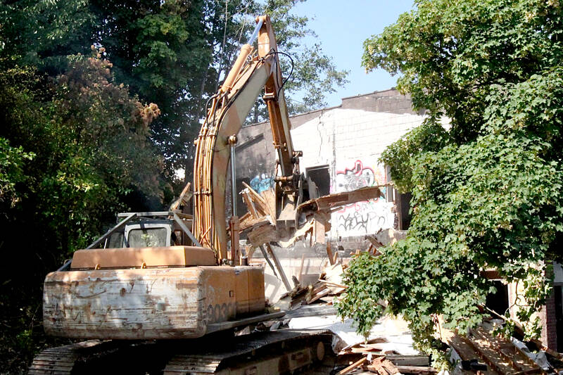 Demolition began Monday morning on the derelict two-story brick building at 204 E. Front St. in Port Angeles. A 300-foot section of Front Street will be shut down while the work is being done, and that could stretch into next week. The developer has said he has plans for an apartment building on the site. (Dave Logan/for Peninsula Daily News)