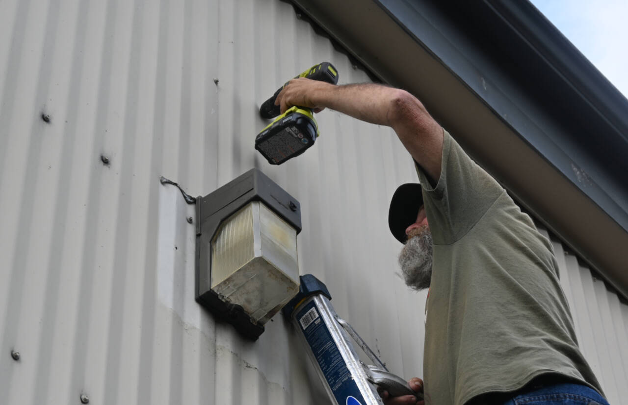 Michael Murphy of Olympic TV & Tech prepares for installation of a security camera at Serenity House Store in Sequim. (Michael Dashiell / Olympic Peninsula News Group)