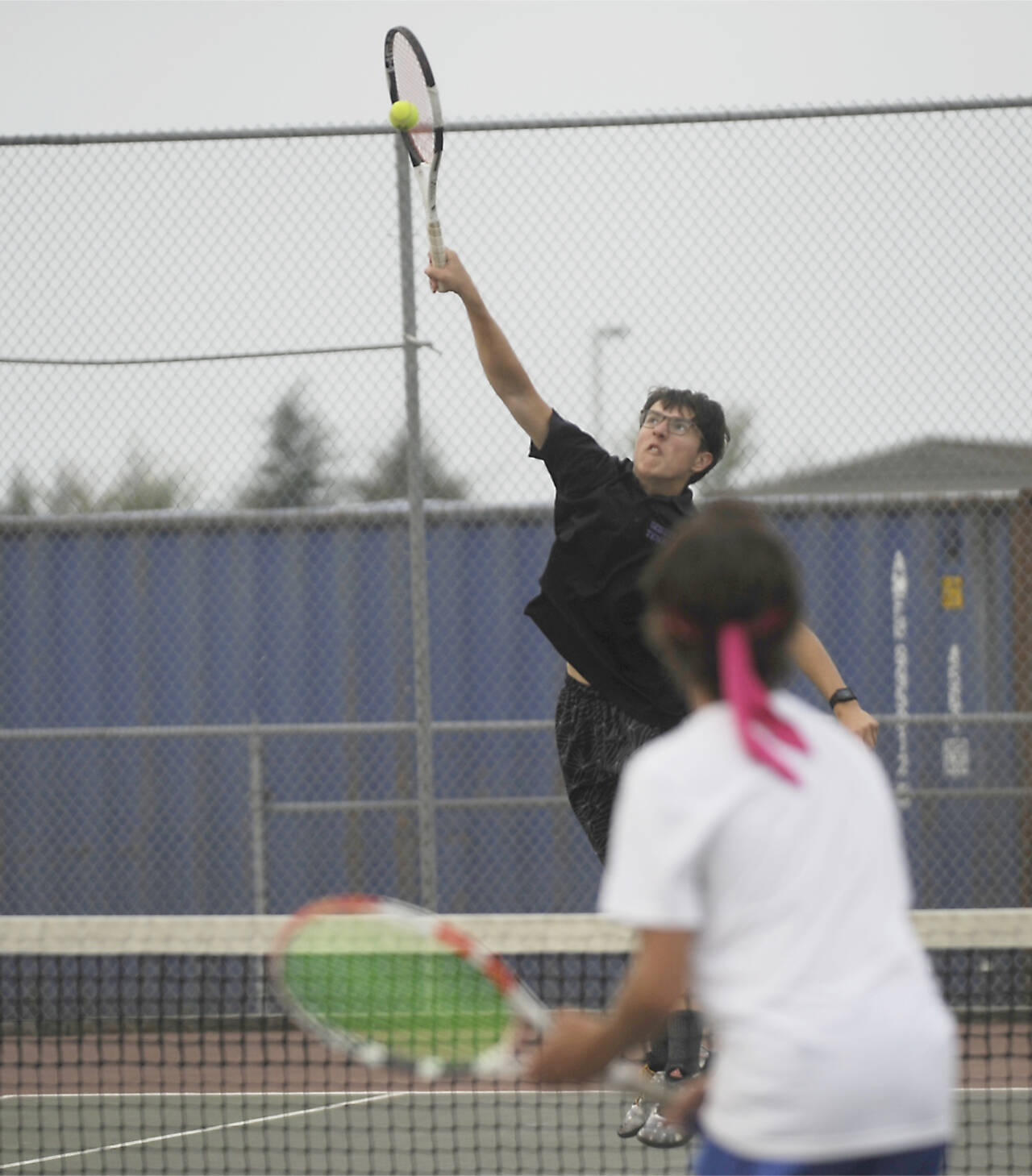 Sequim’s William Hughes returns a shot in tennis action in Sequim against Olympic on Tuesday. (Michael Dashiell/Olympic Peninsula News Group)