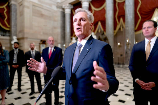 House Speaker Kevin McCarthy, R-Calif., joined by Rep. August Pfluger, R-Texas, right, and other GOP members, talks to reporters just after voting to advance appropriations bills on the House floor at the Capitol in Washington on Tuesday night. McCarthy is digging in on his refusal to take up Senate legislation designed to keep the federal government fully running beyond midnight Saturday. (J. Scott Applewhite/The Associated Press, File)