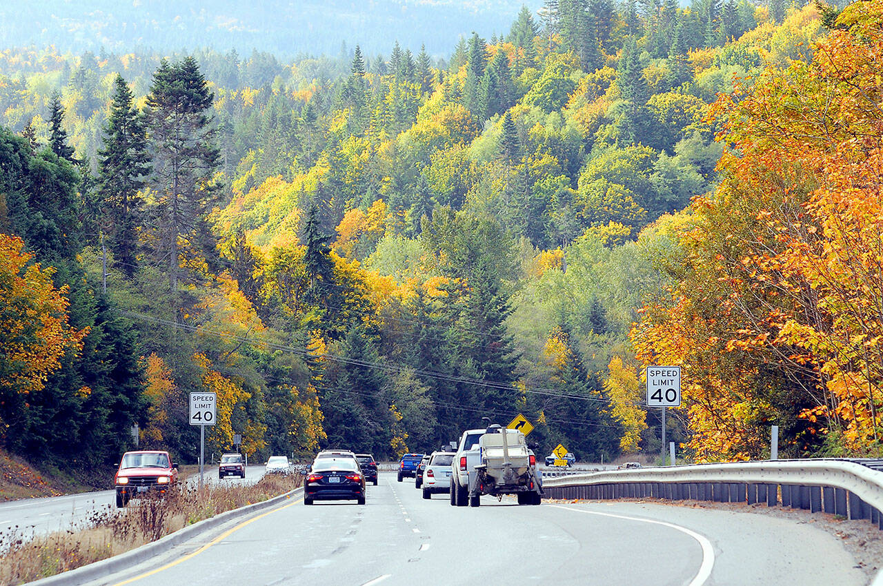 Traffic makes its way down U.S. Highway 101 at Morse Creek east of Port Angeles against a backdrop of colorful fall foliage. With autumn getting into full swing, trees are going into their fall colors before falling into the grayness of winter. (Keith Thorpe/Peninsula Daily News)