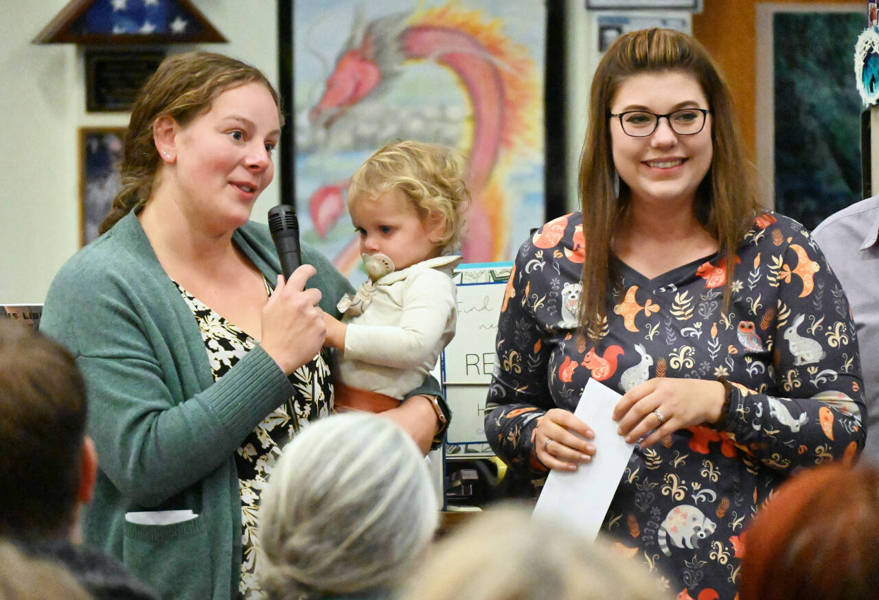 Brianne Lawson, treasurer with Peninsula Pre-3 Cooperative (with 16-month-old Charlie) and fellow board member Kelsey Wheeler accept a $4,150 grant from the Albert Haller Foundation. (Michael Dashiell/Olympic Peninsula News Group)