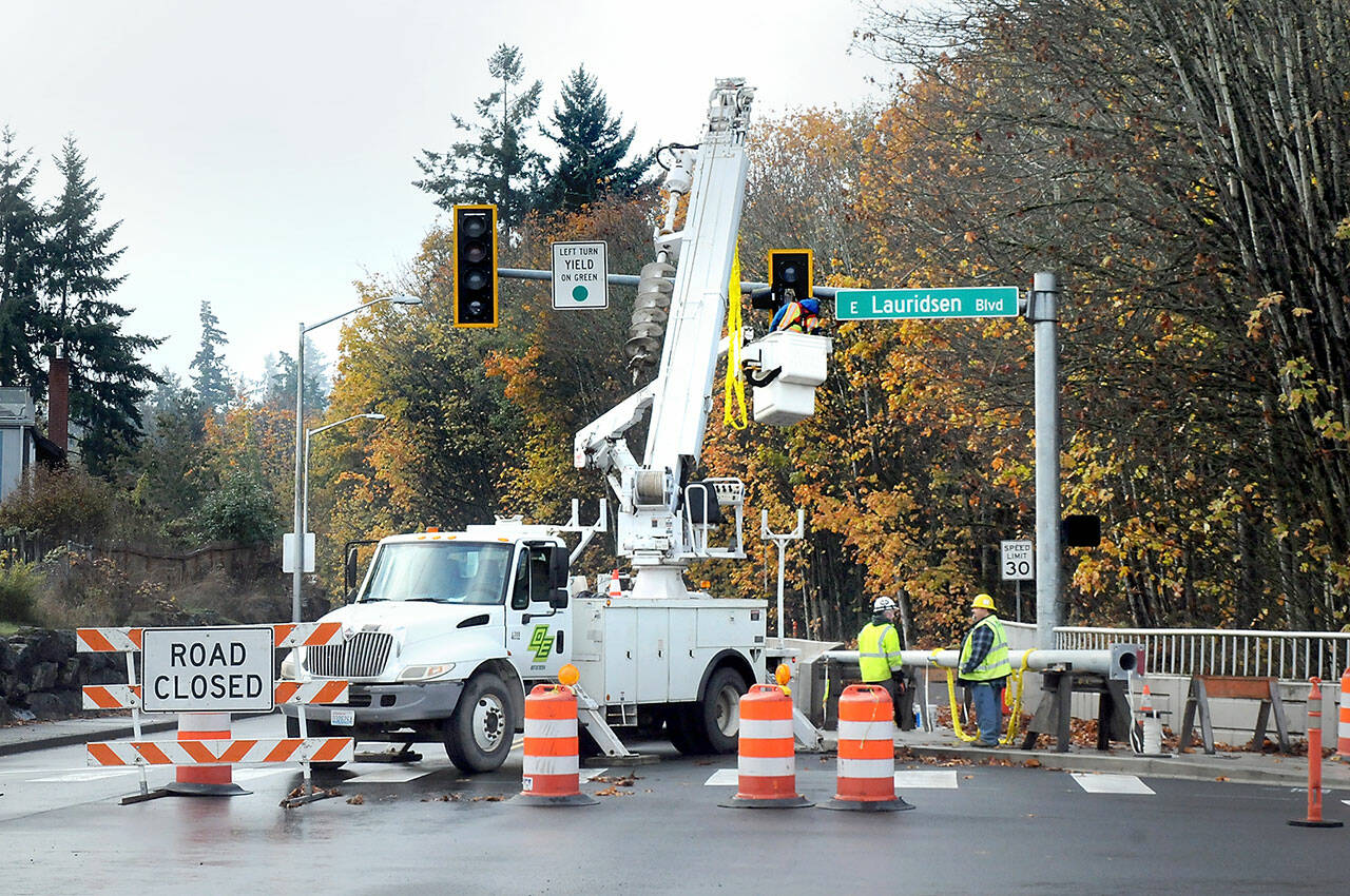 A crew from Olympic Electric Co. works to upgrade a traffic signal at Race Street and Lauridsen Boulevard in Port Angeles on Thursday as part of Phase One of the Race Street Corridor upgrade project. The first part of the project includes a pedestrian trail, improved crosswalks, stormwater infrastructure replacement and landscaping between Eighth Street and Olympus Avenue. (Keith Thorpe/Peninsula Daily News)