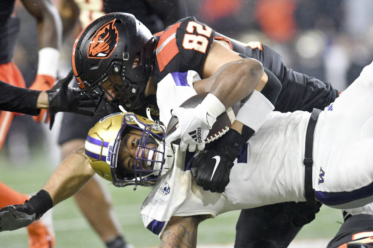 Washington running back Dillon Johnson is brought down by Oregon State linebacker Cory Stover (82) during the second half of an NCAA college football game Saturday, Nov. 18, 2023, in Corvallis, Ore. (Mark Ylen/The Associated Press)