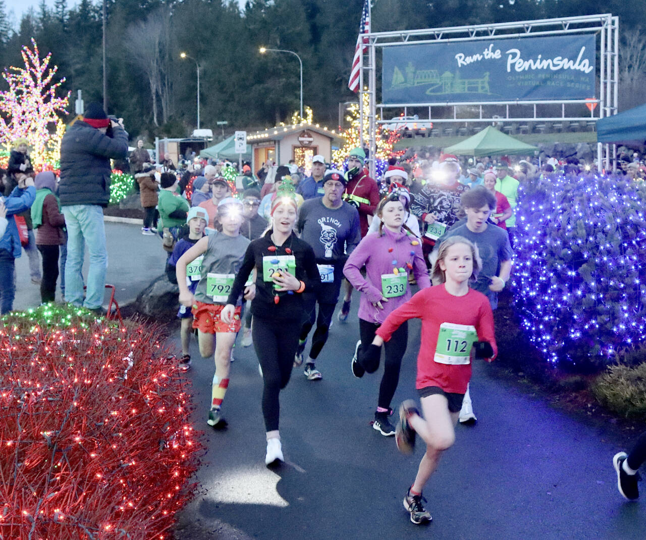 Eleanor Jones, 11, of Sequim (No. 112) leads the pack at the beginning of the Run the Peninsula’s Jamestown Glow Run in Blyn late Saturday afternoon. Jones won the women’s 5K as more than 450 runners participated. (Dave Logan/for Peninsula Daily News)